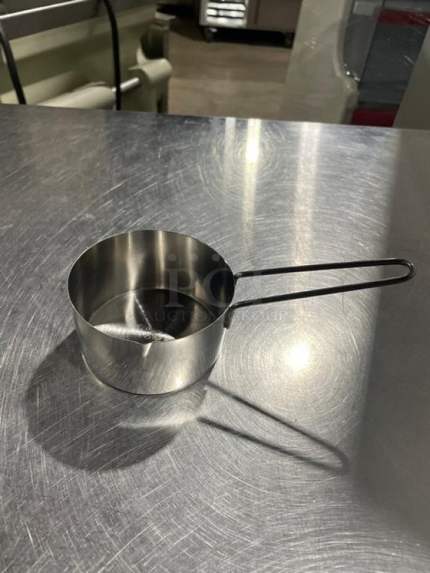 New commercial stainless steel measuring cup with a sleek design, sturdy handle, and shiny finish, perfect for precise measurements.