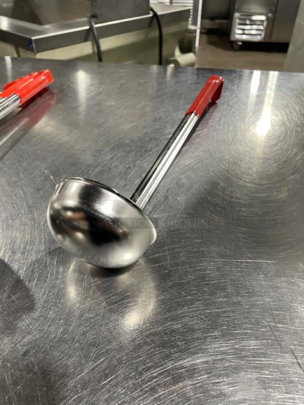 Polar Ware stainless steel 4 oz. ladle with red grip handle, new condition, on metal surface.