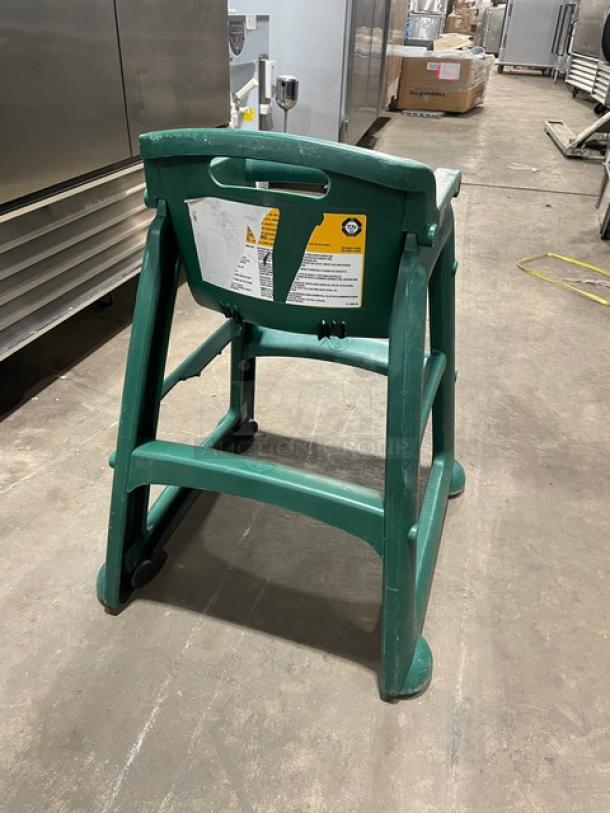 Green commercial stackable highchair with strap, buckles, and casters. Durable design, visible labels, excellent condition.