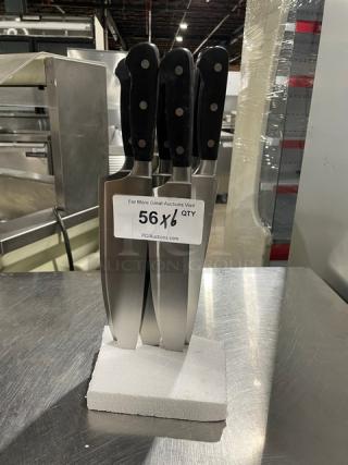 Set of new commercial stainless steel chef knives with black grip handles. Includes multiple knives. Auction quantity label: 56X.