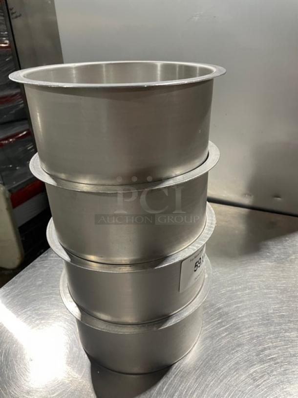 Stack of four commercial round stock pots in stainless steel. Each pot appears in good condition. Auction label visible on one pot.