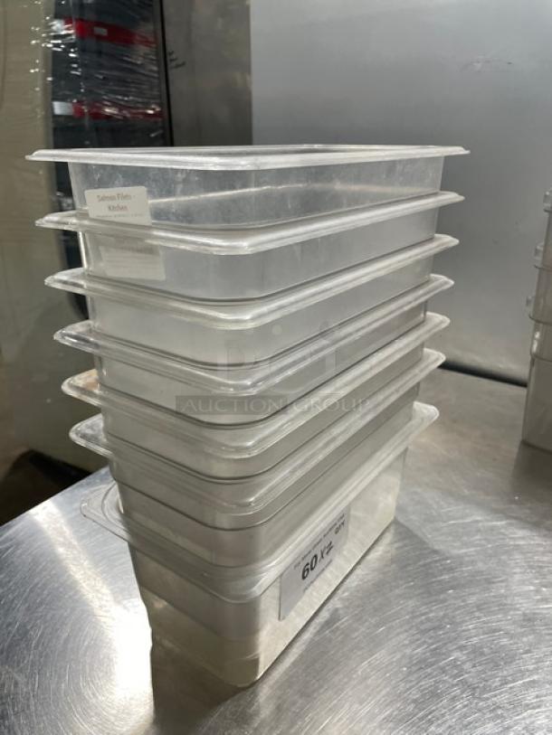 Cambro commercial clear polycarbonate food pans stacked, in good condition. Labels indicate "Salmon Filets" and "60 oz."