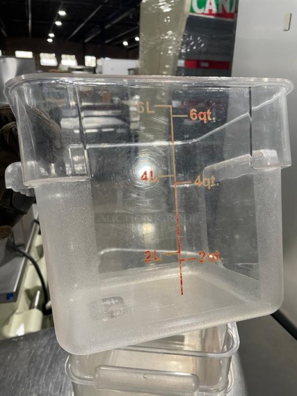 Winco clear polycarbonate 6 Qt. food storage container, marked with quart and liter measurements, in good condition.