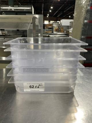 Stack of six commercial clear polycarbonate food pans. Label reads "62 x Qty," indicating bulk quantity. Auction item.