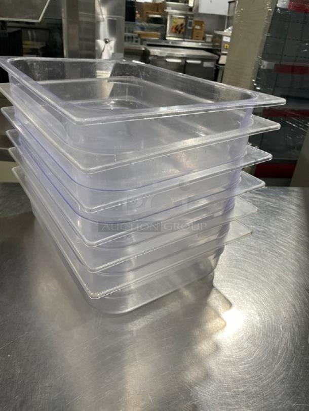 Stack of commercial clear polycarbonate food pans, new condition, durable and versatile, sold as a set of six.