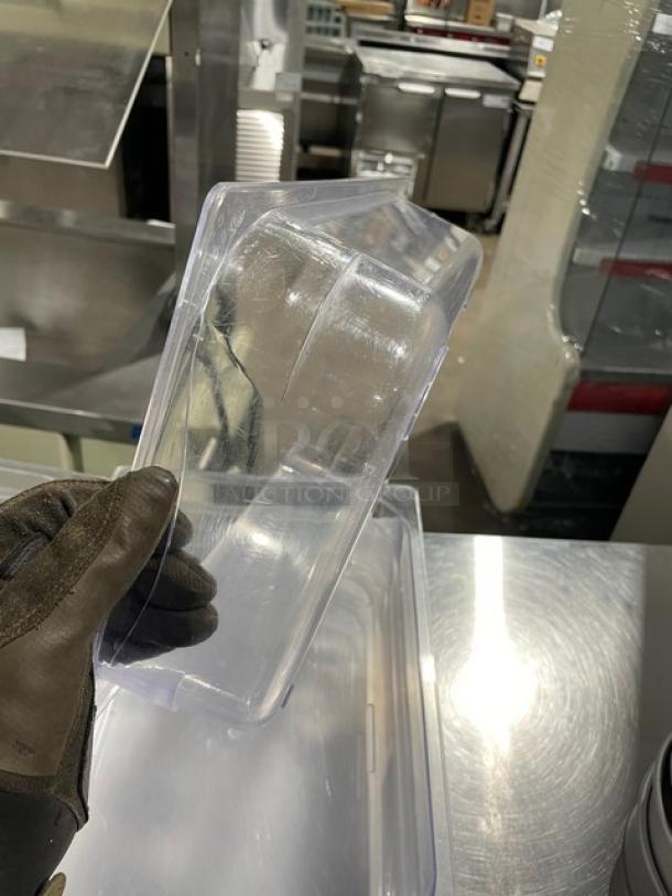 Clear polycarbonate food pan with slight surface scratches. Suitable for commercial use. Durable material, perfect for kitchen storage.