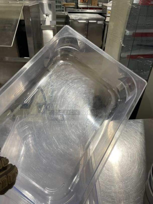 Clear polycarbonate food pan for commercial use, rectangular, showing light wear, ideal for storage or prep.