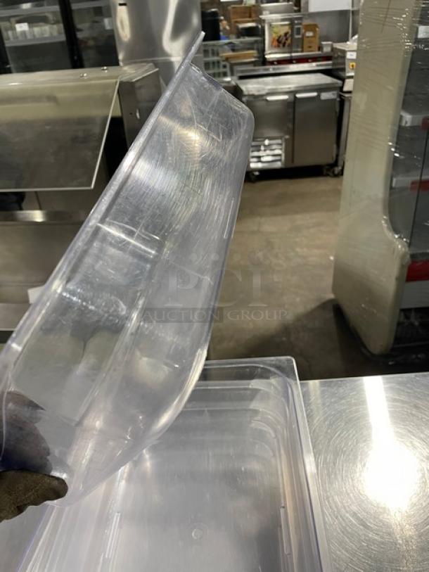 Commercial clear polycarbonate food pan, durable and scratch-resistant, shown in an industrial kitchen setting.