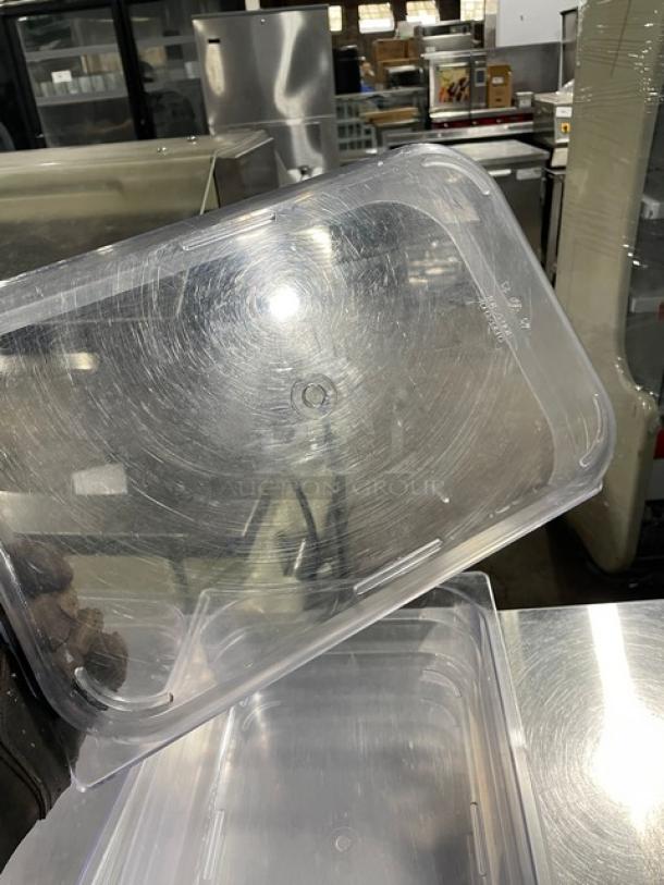 Commercial clear polycarbonate food pan, rectangular, light scuff marks, durable, ideal for kitchen storage and prep.
