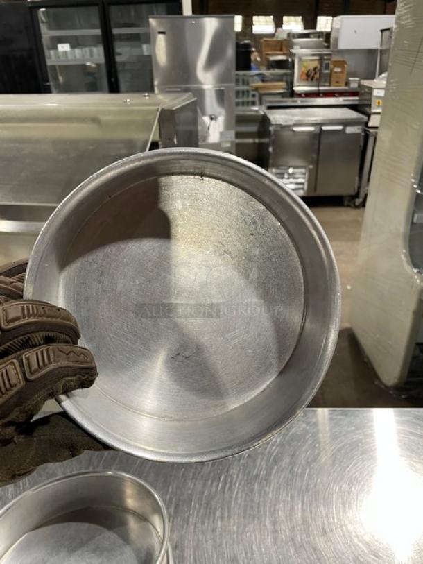 Commercial round baking pan, stackable, metal, gently used. Ideal for baking or food service. Visible kitchen setting.