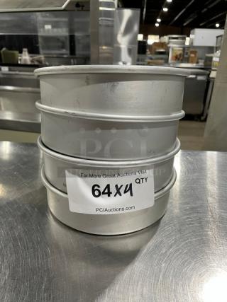 Commercial round baking pans, stack of four. Silver metal, good condition. Label reads "64X4 QTY, PCIAuctions.com."