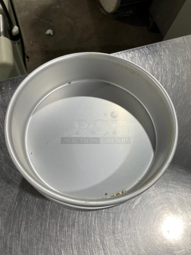 Commercial round baking pan, metal, used condition with slight stains; ideal for stacking multiple pans.