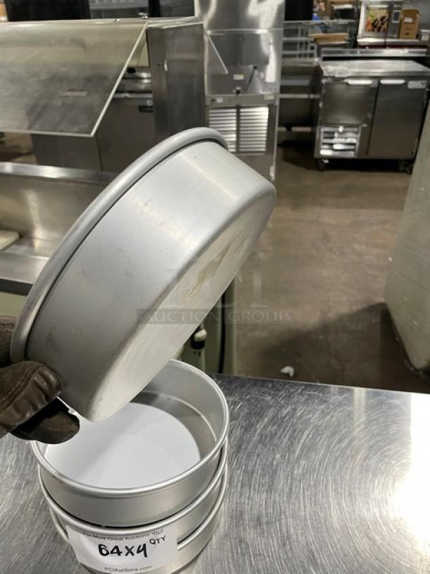 Commercial round baking/stacking pan, metal construction, used condition, stackable design. Label reads "64X4 QTY".