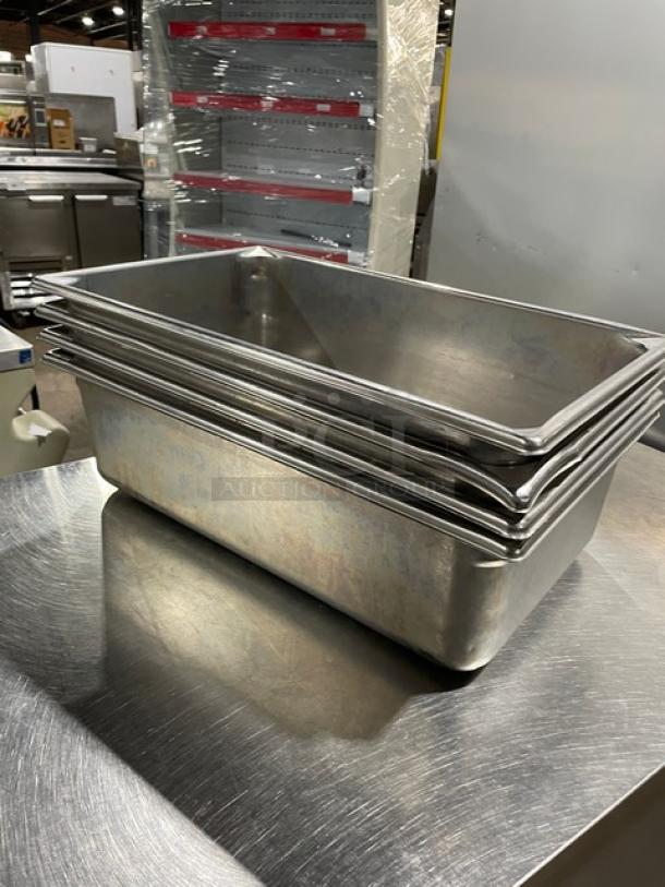 Commercial stainless steel steamtable pans, stack of four, used condition, durable and ideal for hotel or catering use.