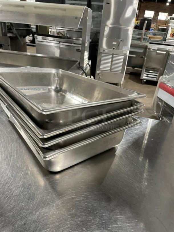 Commercial stainless steel hotel steamtable pans, set of four. Stackable, durable, used condition. Ideal for catering.