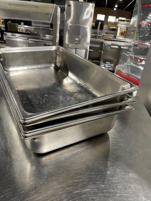 Commercial stainless steel hotel/steamtable pans, stack of three, used condition, durable catering essentials.
