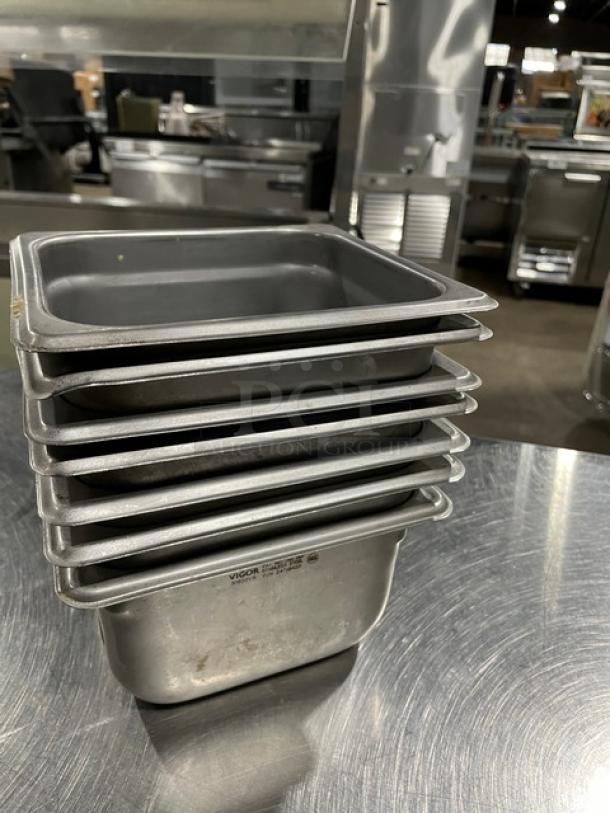Stack of commercial stainless steel steamtable pans by Vigor, used condition, 7 pans total.
