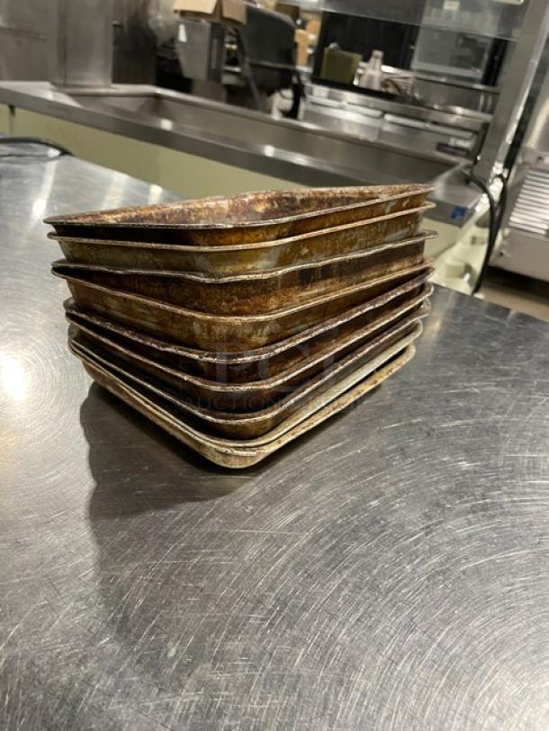 Stack of vintage commercial mini baking pans, showing wear and patina, in fair condition. 9 pans total.