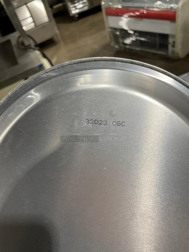 Commercial round pie pan, appears in new condition, marked "32023 CGC" on surface, ideal for industrial baking.