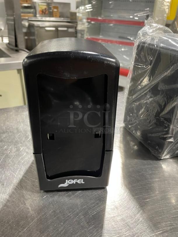 NEW Jofel black tabletop napkin dispenser on legs, tall-fold design. Logo visible, excellent condition. Multipack of 6 available.