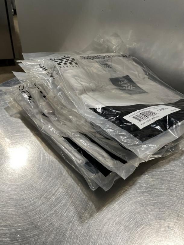 Brand new Chef Revival chef jackets, model J070WT-S, poly/cotton blend, sealed in packaging, with product labels visible.
