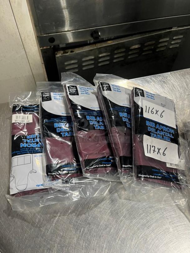 Brand new Chef Revival 612BAFHBG bib aprons in burgundy, sealed in plastic. Features three lower pockets. One-size-fits-most.