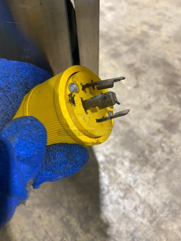 Yellow 208V 3-phase power plug for ColdElite UF8202 ice cream machine, held with a blue glove.