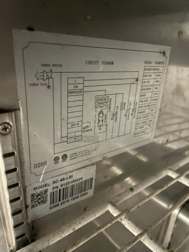 Universal Coolers SC-48-LBI stainless steel refrigerator with poly-coated racks and circuit diagram label visible. Model SN: 6398251018080202.