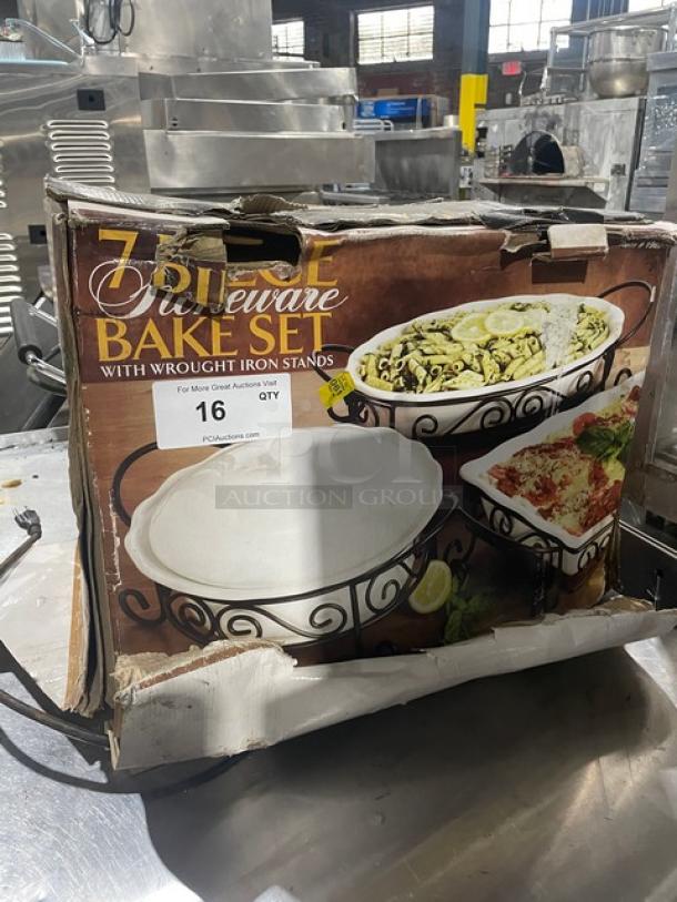 7-piece stoneware bake set with wrought iron stands, new condition, original packaging, includes various bakeware shown on box.