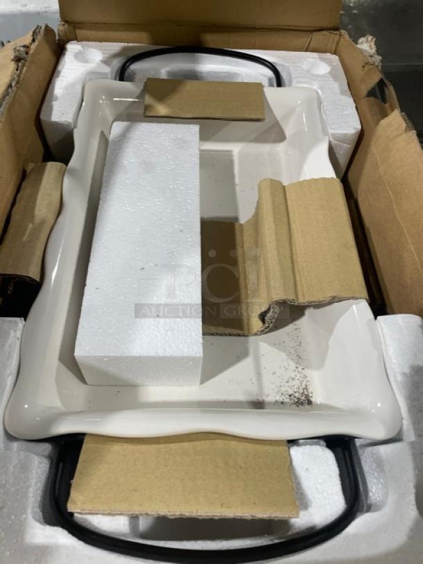 New commercial stoneware bake set with wrought iron stand, still in original packaging. Includes protective cardboard and foam inserts.