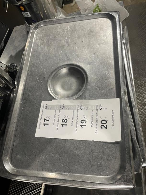 Commercial stainless steel steamtable pan lid, rectangular with center handle indentation. Good condition, minor surface marks.