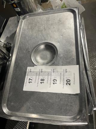 Commercial stainless steel hotel steamtable pan lid, rectangular with central handle. Slight scratches visible.