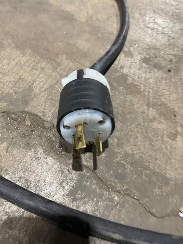 Close-up of a power plug attached to the Fetco CBS2132XTS coffee brewer. Durable design, suitable for commercial use.