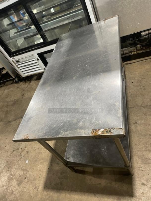 Sapphire commercial stainless steel worktop table with undershelf and legs. Surface shows signs of wear and rust at corners.