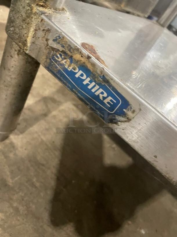 Sapphire stainless steel worktop table, single undershelf, on legs, visible wear, brand label partially visible.