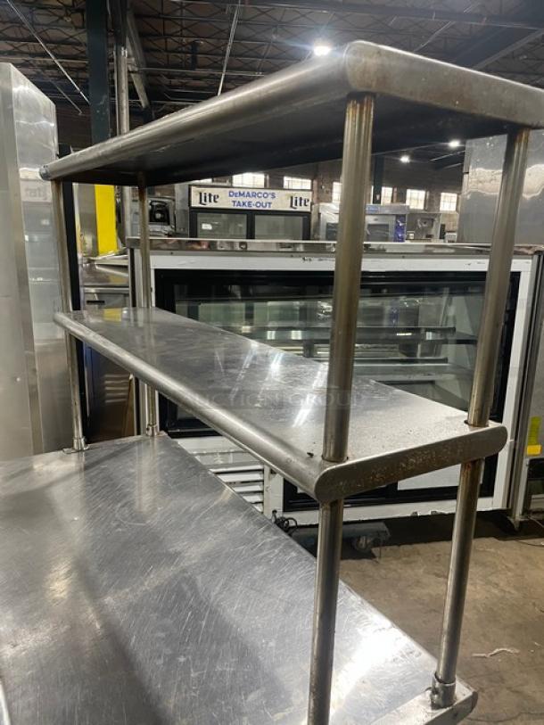Sapphire stainless steel worktop table with single undershelf, double overhead shelf, and sturdy legs; industrial setting.