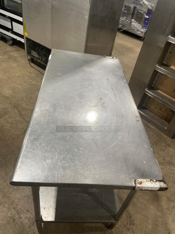 Sapphire commercial stainless steel worktop table with a single undershelf, on legs. Visible wear and scratch marks.