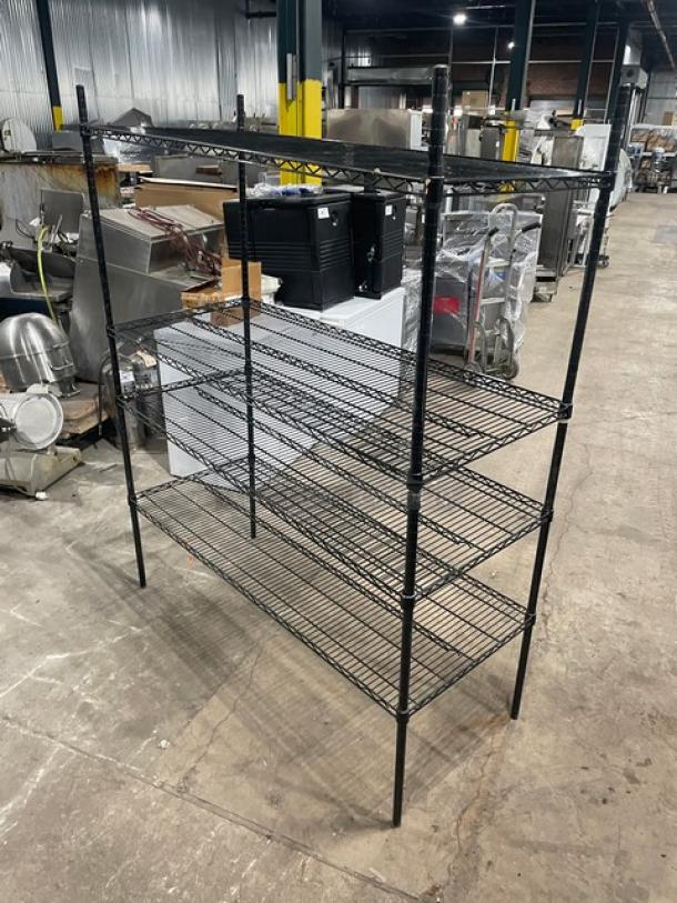 Commercial black 4-tier utility wired rack on legs, durable metal construction, excellent condition. Ideal for storage.