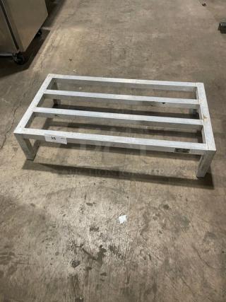 Commercial aluminum dunnage rack on legs, sturdy metal construction, rectangular design, measures approximately 30x18x8 inches, used condition.