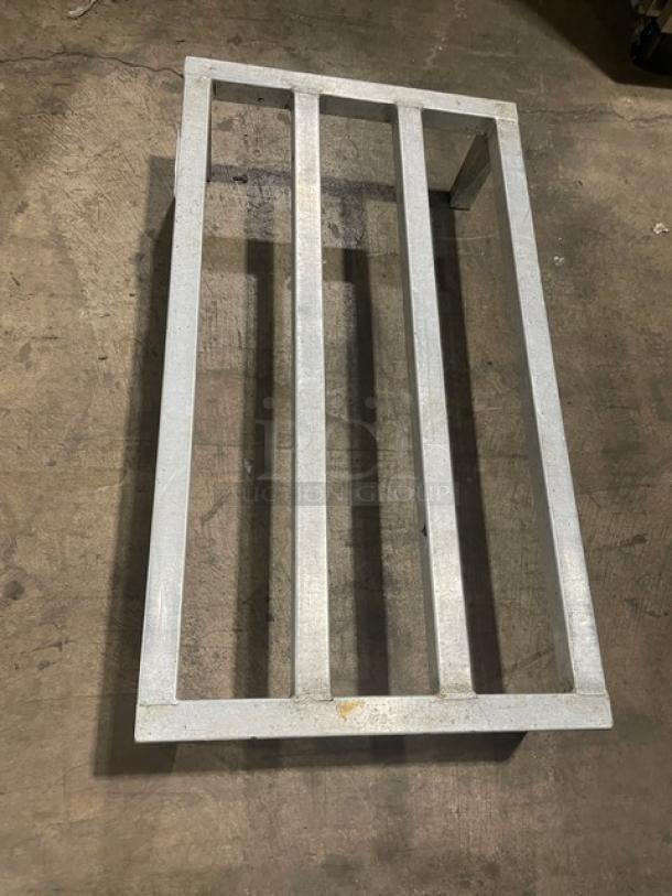 Commercial aluminum dunnage rack with legs, featuring a sturdy metal frame and parallel slats. Good condition.