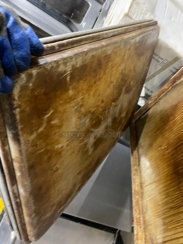 Commercial full-size baking sheet pan, used, stack of two, metal with natural patina, robust build for heavy-duty use.