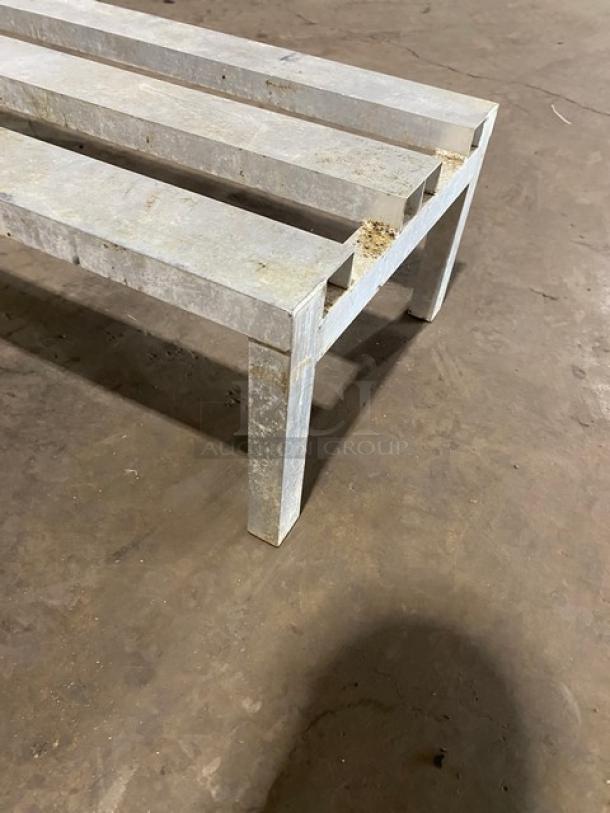 Commercial aluminum heavy-duty dunnage rack on legs, showing wear. Sturdy slatted design for storage, suitable for industrial use.