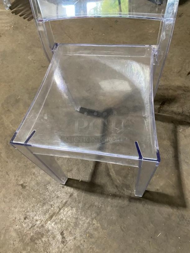 Clear stackable dining chair with legs, suitable for indoor/outdoor use. Transparent material, sturdy, in good condition.