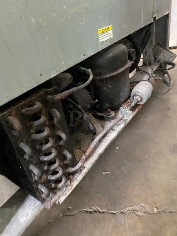 Beverage-Air SP60-16 commercial stainless steel refrigerated prep table on casters, visible compressor, showing wear and rust.