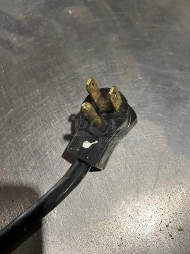 Black power plug of Beverage-Air Worktop Freezer WTF27A on stainless steel surface. Plug shows minor wear.