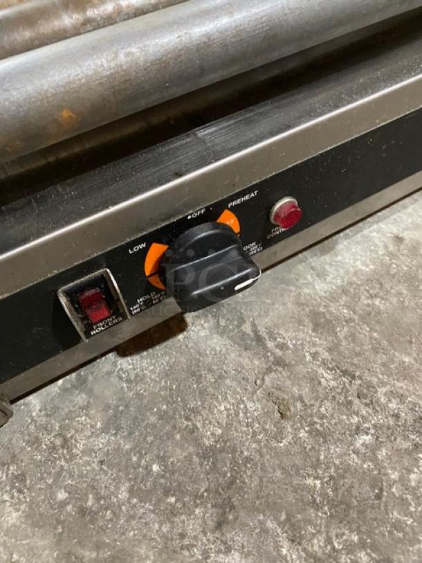 Nemco stainless steel electric countertop hot dog roller grill with control knob, indicator lights, and visible wear.