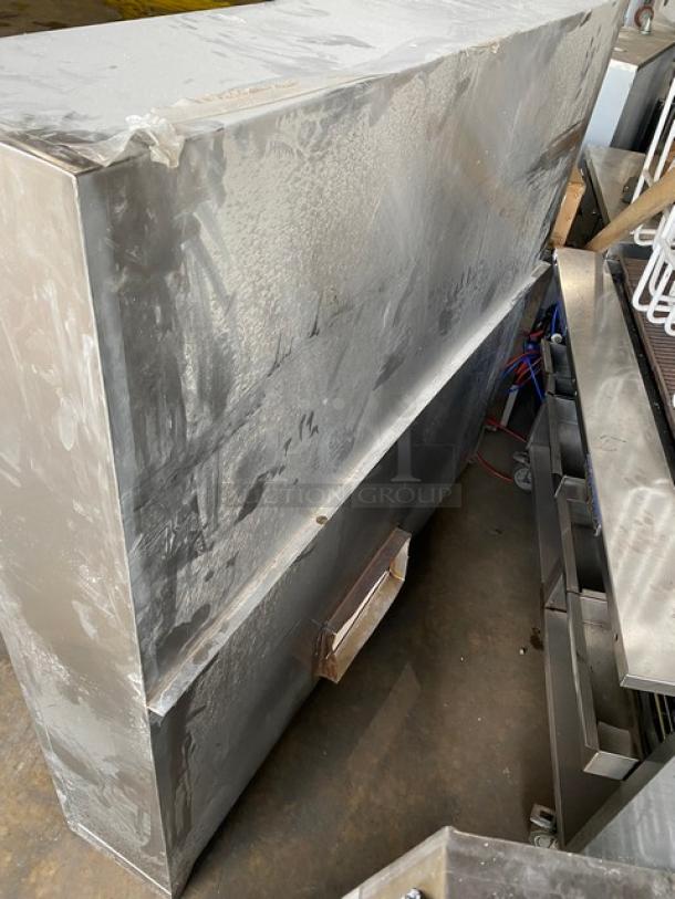 Commercial stainless steel kitchen exhaust hood in fair condition. Features a sleek rectangular design with visible surface marks.