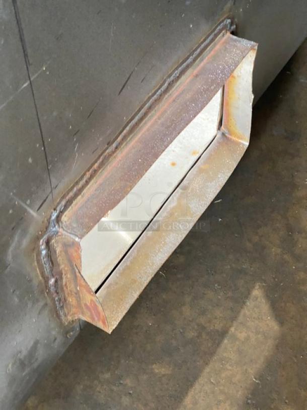 Commercial stainless steel kitchen exhaust hood, features visible duct connection, slight wear, suitable for industrial use.
