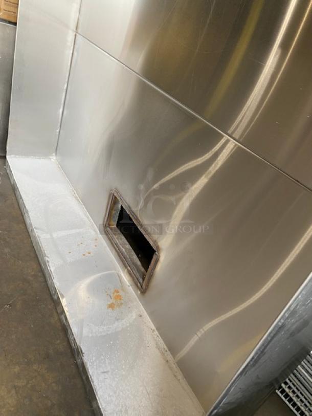 Commercial stainless steel kitchen exhaust hood, used condition, visible surface wear, rectangular vent opening.