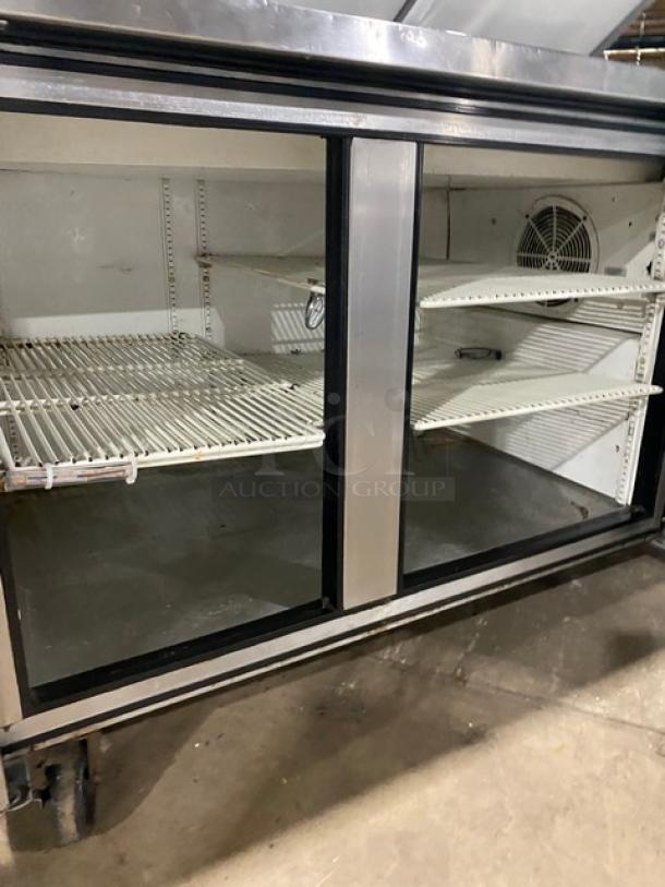 True Commercial TPP-60 2-door refrigerated pizza prep table with poly coated wired rack, stainless steel, on casters.